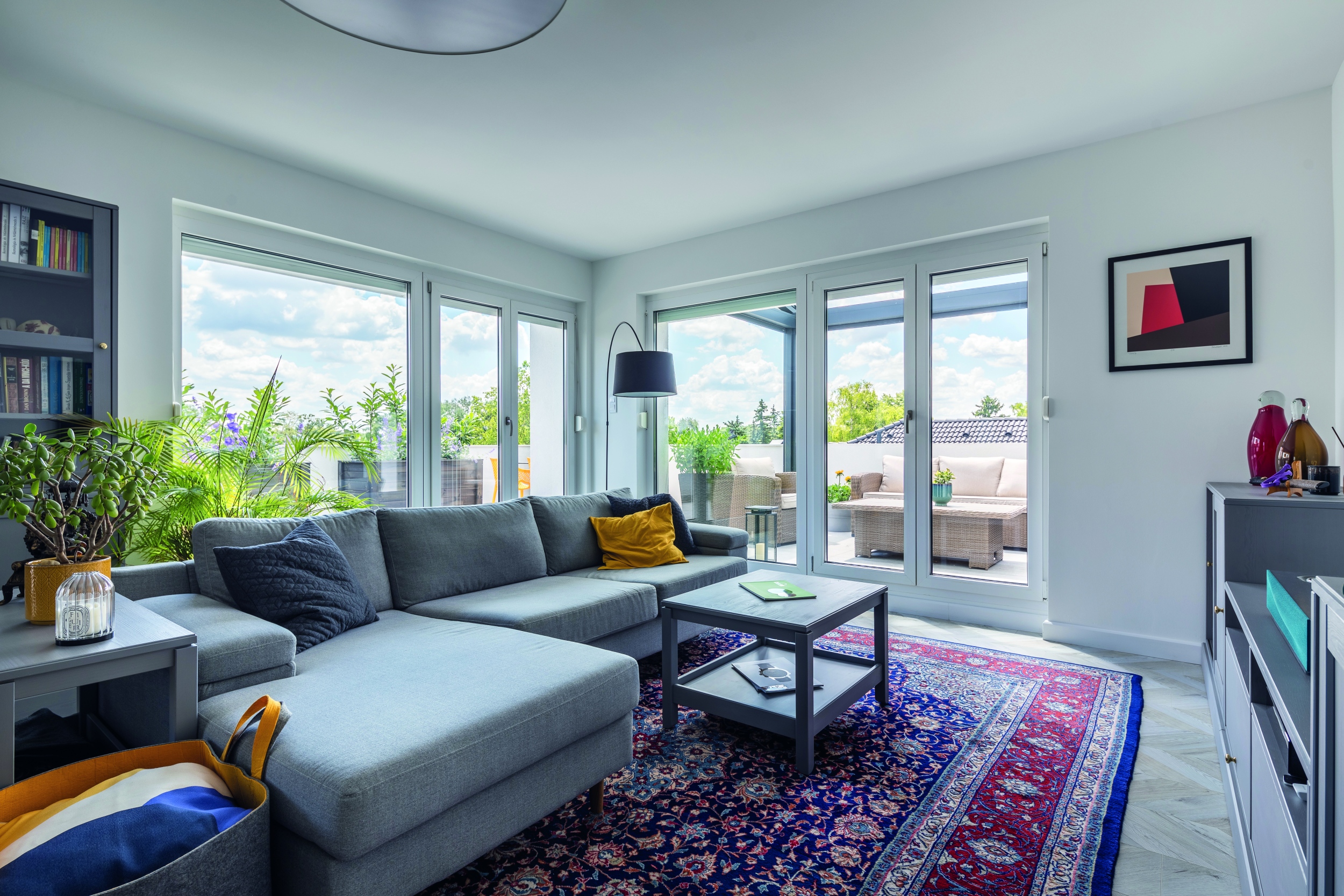 Körbejárható, L alakú  kanapé jelöli ki a nappali terét a többfunkciós, tágas térben,  ami impozáns méretű  üveg nyílászárókkal  nyit a kényelmes  terasz felé, miközben  páratlan kilátással  ajándékozza meg  a nappalit